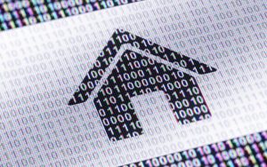 Close-up of a printed sheet of binary digits with a house-shaped arrow cut out of the numbers, suggesting personal data being extracted.